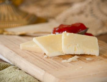 slices of artisan white cheddar with jam on a wooden serving board