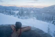 woman in hot tub looking at snowy mountain
