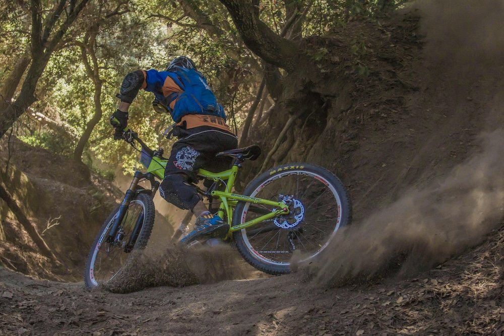 person on a mountain bike going along a dusty trail