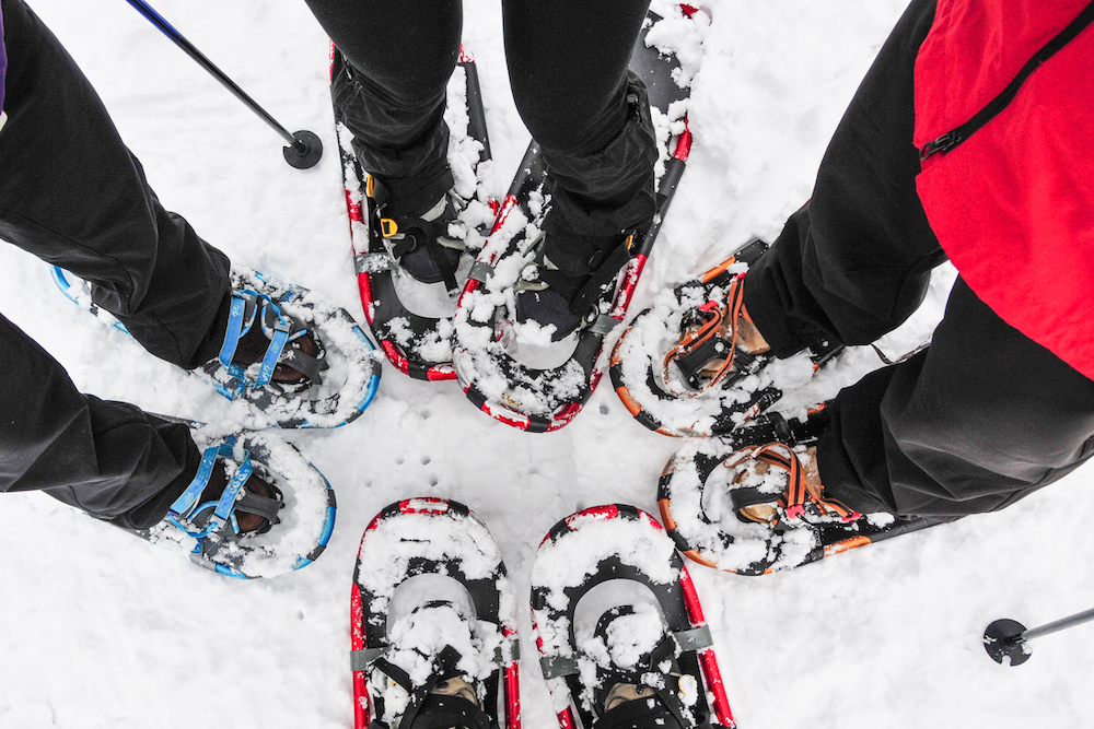 view of family's feet in snowshoes outside in the snow
