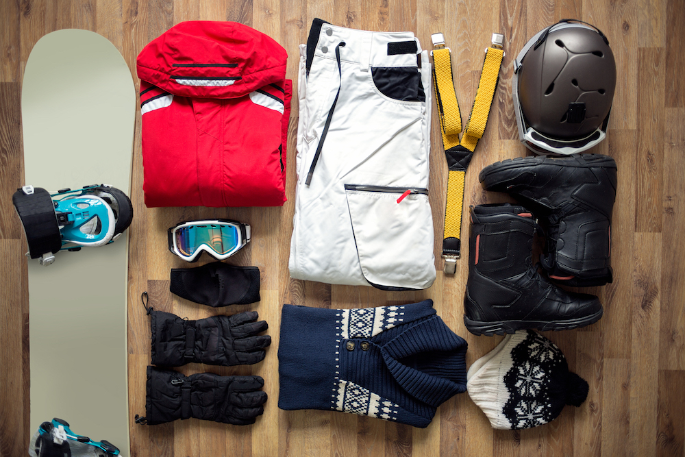 Winter gear laid out on display: snowboard, boots, goggles, sweaters, etc.